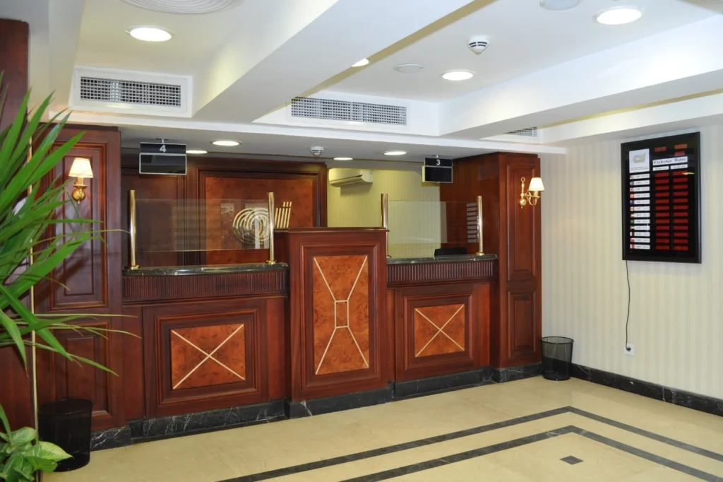 Glass office meeting room with wooden desk and modern ceiling design
